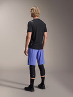 Alpinestars A-Aria Switch Jersey, Short Sleeve MTB Jersey, Black, rear view on model wearing blue shorts and black knee guards, performance cycling gear for trail riding