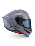 Casco Alpinestars S-R7 Solid, casco integral de moto, gris brillante, vista de perfil lateral, calota aerodinámica gris brillante con logotipo negro y acentos rojos en la base, equipo de alto rendimiento para carreras y conducción deportiva