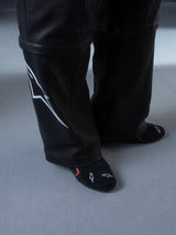 Alpinestars RSRV Starline Shoes, pantalones negros con líneas gráficas blancas laterales, calcetines negros con diseños rojos y blancos, textura suave y brillante