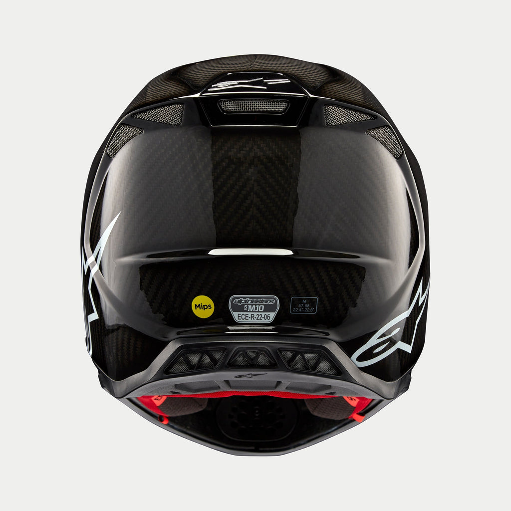 Casco Alpinestars Supertech M10 Solid, carbono negro brillante, vista trasera que muestra el tejido de fibra de carbono brillante, logotipo de Alpinestars en blanco, pegatinas de certificación MIPS y ECE, forma aerodinámica con puertos de ventilación