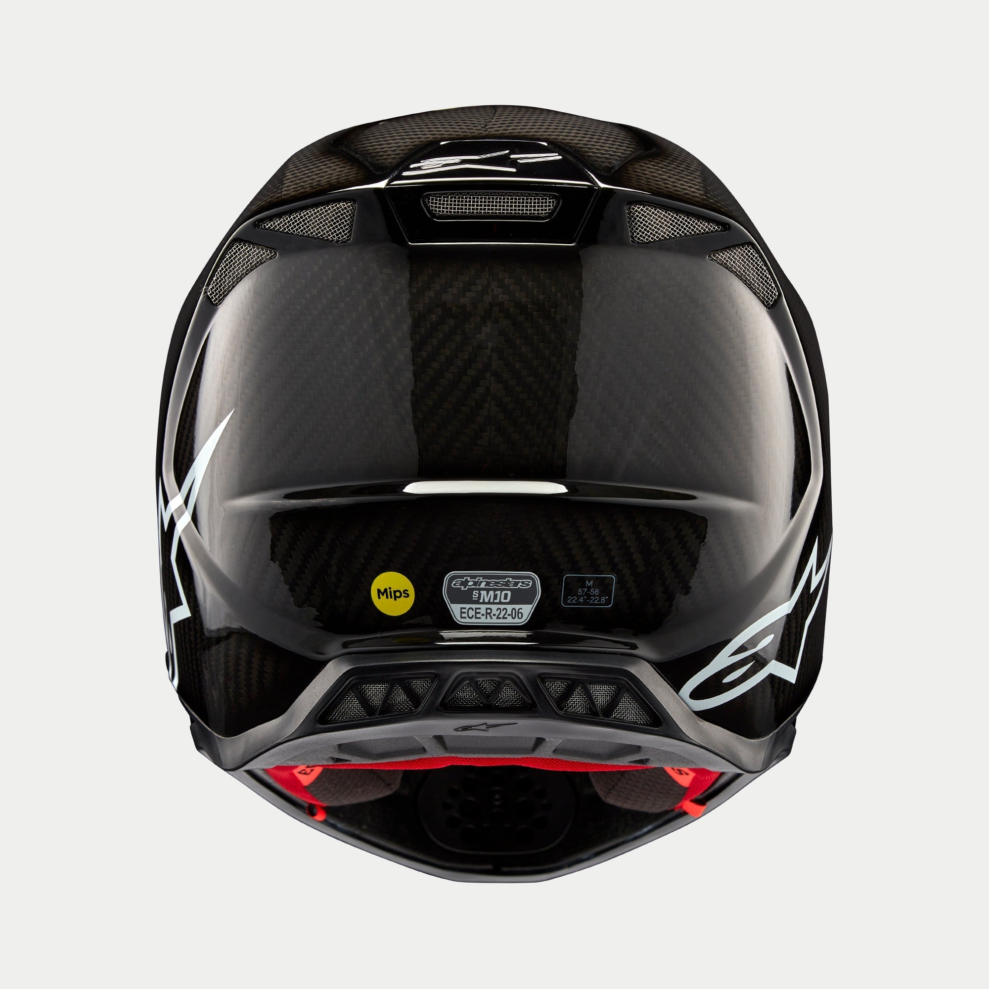 Casco Alpinestars Supertech M10 Solid, carbono negro brillante, vista trasera que muestra el tejido de fibra de carbono brillante, logotipo de Alpinestars en blanco, pegatinas de certificación MIPS y ECE, forma aerodinámica con puertos de ventilación
