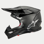 Casco Alpinestars Supertech M10 Fame ECE 22.06, vista de perfil lateral, acabado en carbono negro mate y brillante, con tejido de fibra de carbono visible, logotipo de Astars plateado en el lateral, diseño aerodinámico con puertos de ventilación integrados y visera negra