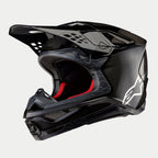 Casco Alpinestars Supertech M10 Fame ECE 22.06, casco de motocross, acabado en carbono negro mate y brillante, con tejido de fibra de carbono visible, logotipo Astar blanco en el lateral y acolchado interior rojo, diseño aerodinámico para off-road