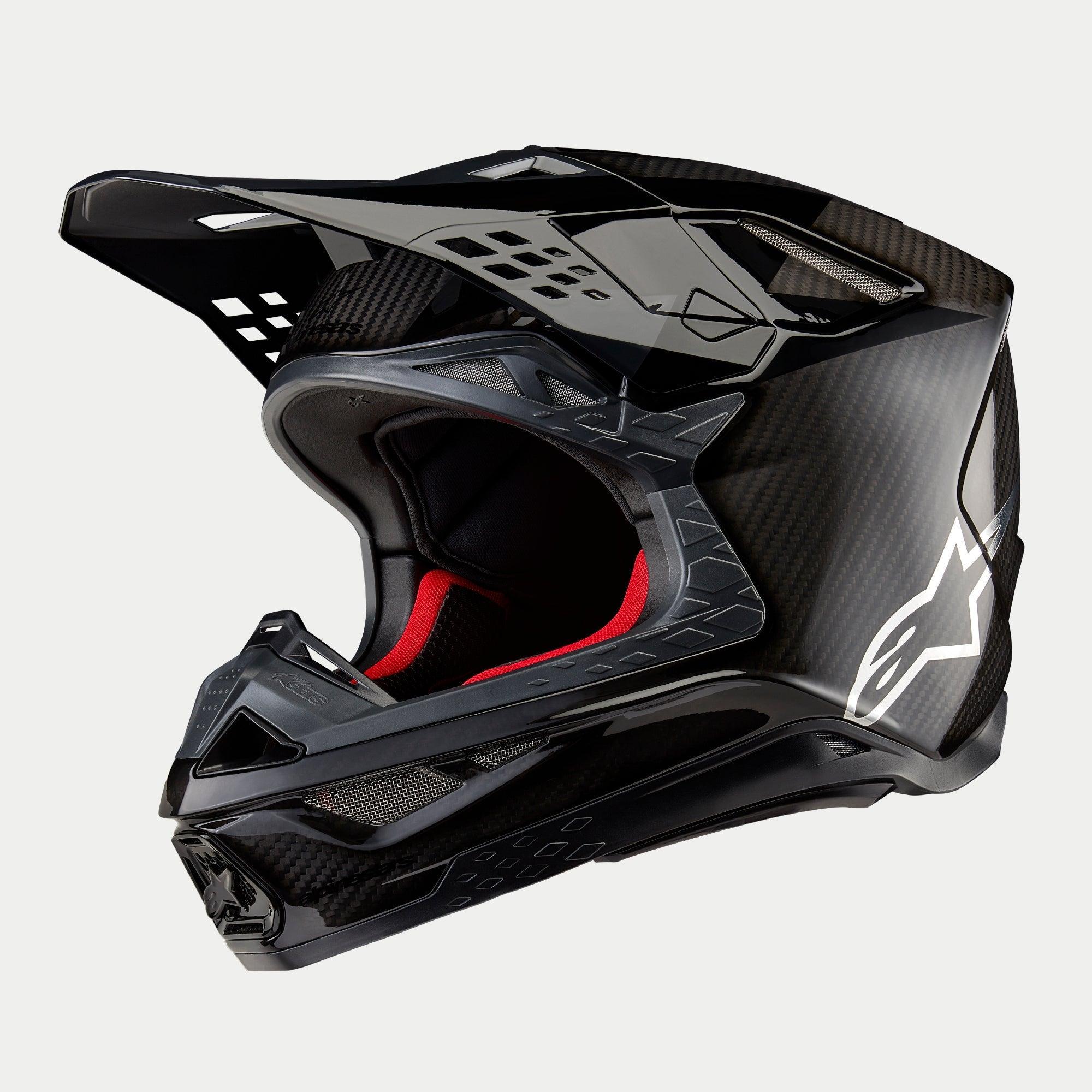 Casco Alpinestars Supertech M10 Fame ECE 22.06, casco de motocross, acabado en carbono negro mate y brillante, con tejido de fibra de carbono visible, logotipo Astar blanco en el lateral y acolchado interior rojo, diseño aerodinámico para off-road