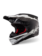 Casco Alpinestars Supertech M10 Ampress, casco de motocross, negro y blanco mate, con llamativos gráficos blancos estilo rayo y logotipos de estrella, forro interior rojo, calota de carbono multicompuesta con un perfil aerodinámico estilizado