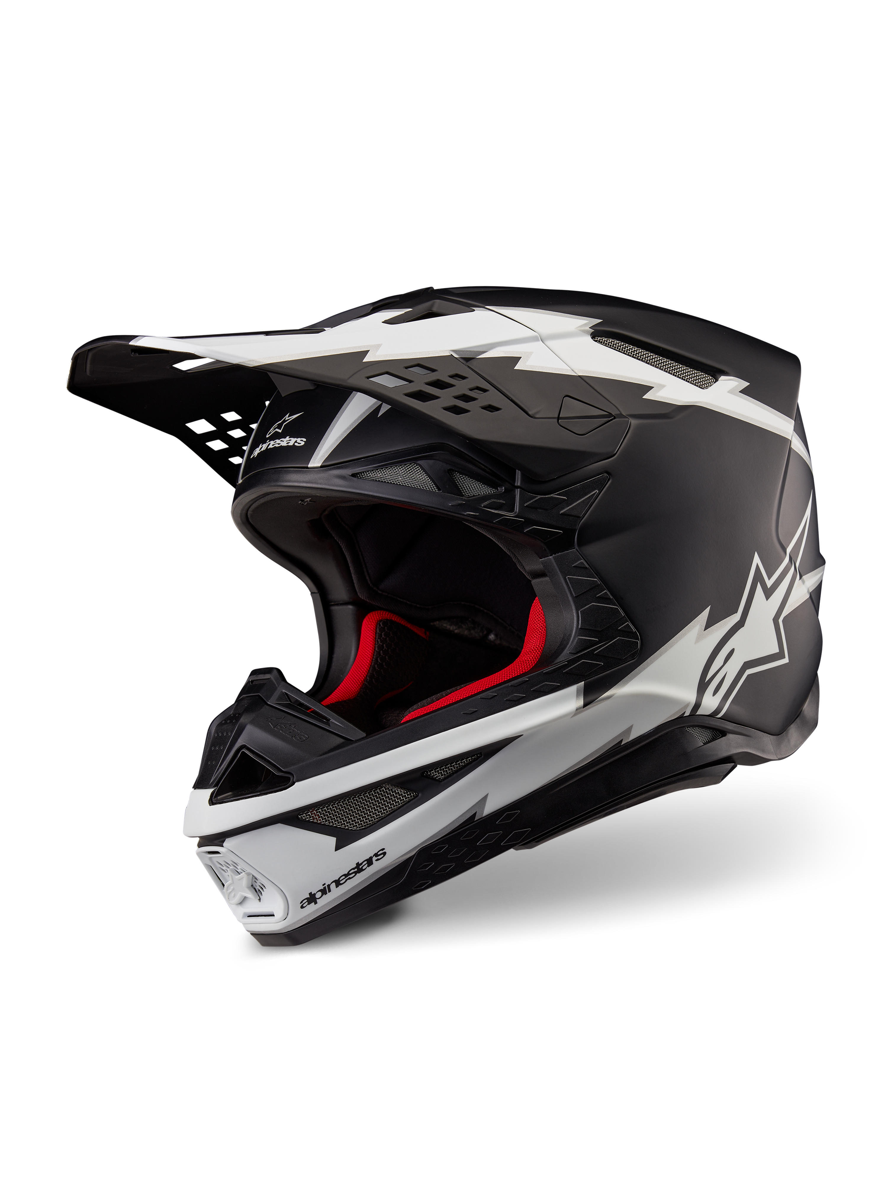 Casco Alpinestars Supertech M10 Ampress, casco de motocross, negro y blanco mate, con llamativos gráficos blancos estilo rayo y logotipos de estrella, forro interior rojo, calota de carbono multicompuesta con un perfil aerodinámico estilizado