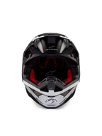 Casco Alpinestars Supertech M10 Ampress, casco de motocross, negro y blanco mate, vista frontal con forro interior rojo, carcasa aerodinámica con puertos de ventilación y logotipo de Alpinestars
