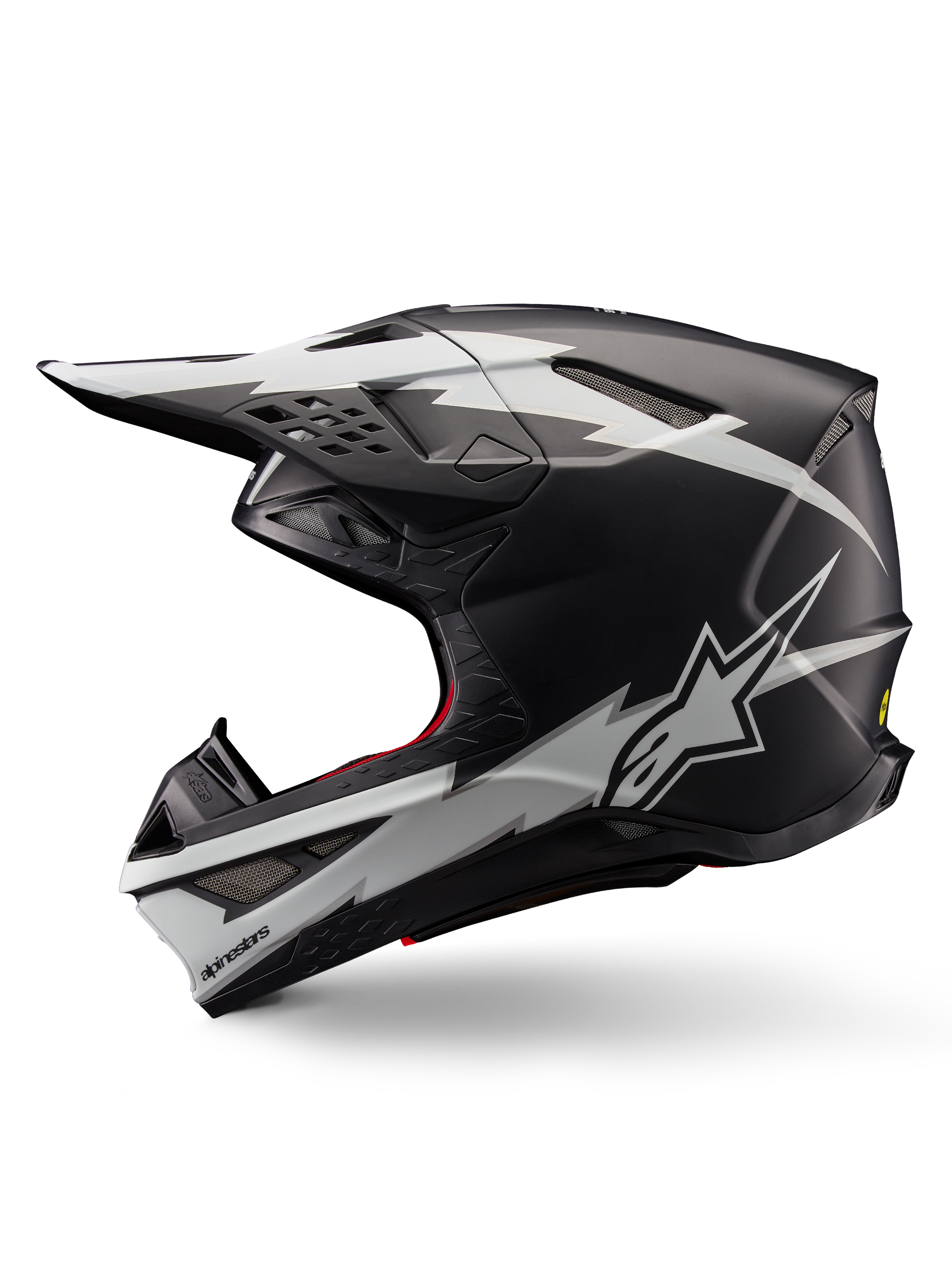 Casco Alpinestars Supertech M10 Ampress, casco de motocross, negro mate y blanco, vista de perfil con llamativos gráficos blancos estilo rayo, carcasa aerodinámica con puertos de ventilación visibles y visera, protección avanzada para todoterreno