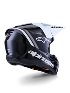 Casco Alpinestars S-M3 Radium, casco de motocross, negro, blanco y gris brillante, vista lateral trasera con visera blanca, con el logotipo de Alpinestars en el lateral y la parte trasera, calota aerodinámica con rejilla de ventilación, diseñado para motocross y enduro