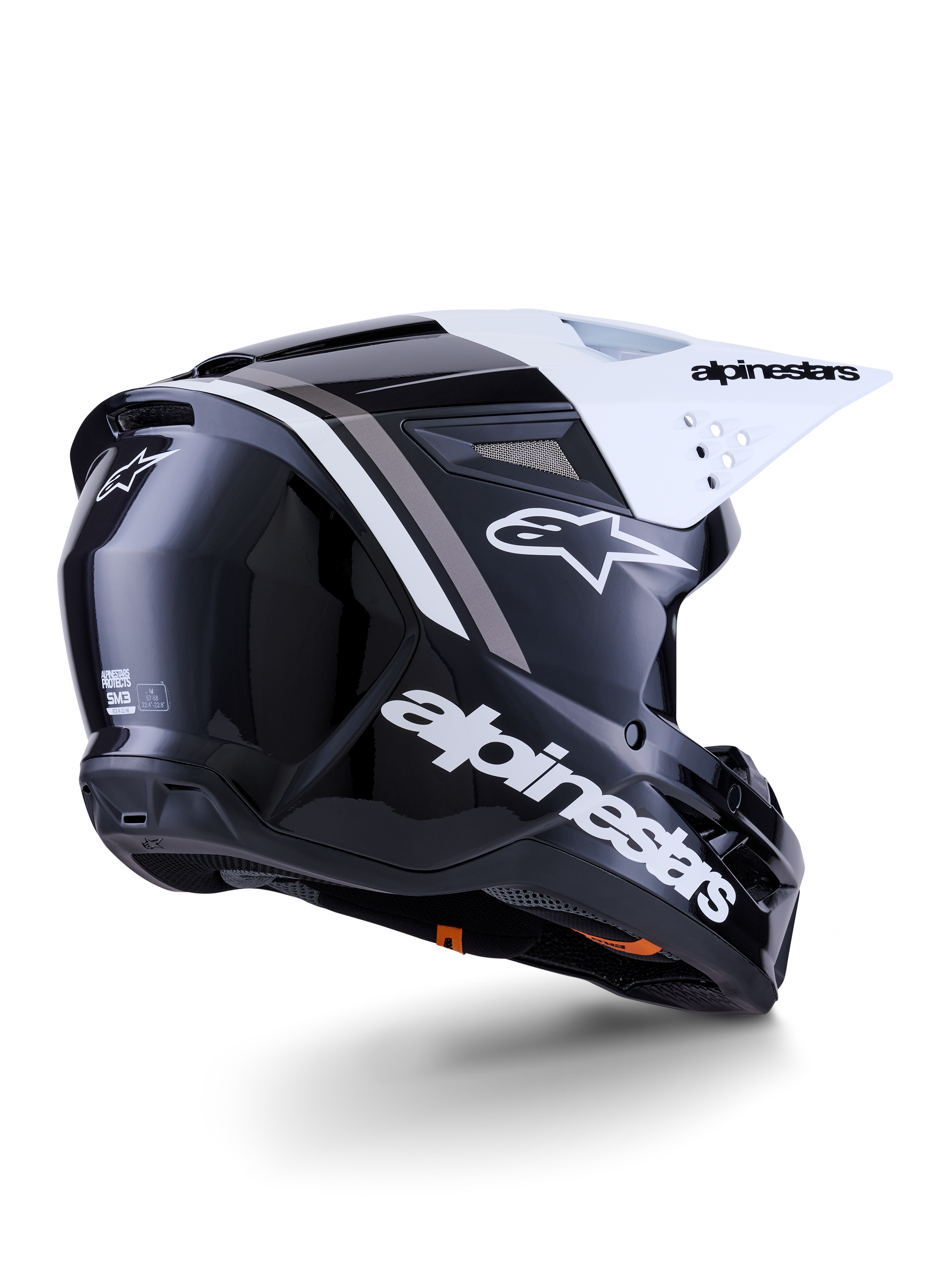 Casco Alpinestars S-M3 Radium, casco de motocross, negro, blanco y gris brillante, vista lateral trasera con visera blanca, con el logotipo de Alpinestars en el lateral y la parte trasera, calota aerodinámica con rejilla de ventilación, diseñado para motocross y enduro