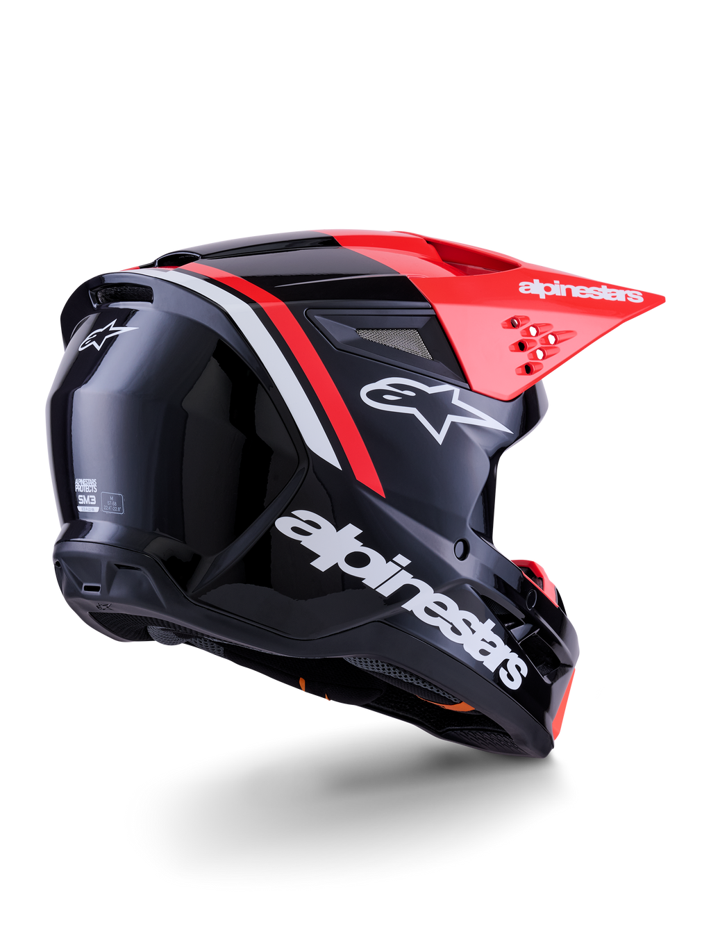 Casco Alpinestars S-M3 Radium, casco de motocross, negro, rojo flúor y blanco brillante, vista trasera de tres cuartos que muestra un diseño aerodinámico elegante, logotipos blancos y visera roja brillante, equipo de protección para la cabeza de alto rendimiento para off-road