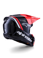 Casco Alpinestars S-M3 Radium, casco de motocross, negro, rojo flúor y blanco brillante, vista trasera de tres cuartos que muestra un diseño aerodinámico elegante, logotipos blancos y visera roja brillante, equipo de protección para la cabeza de alto rendimiento para off-road