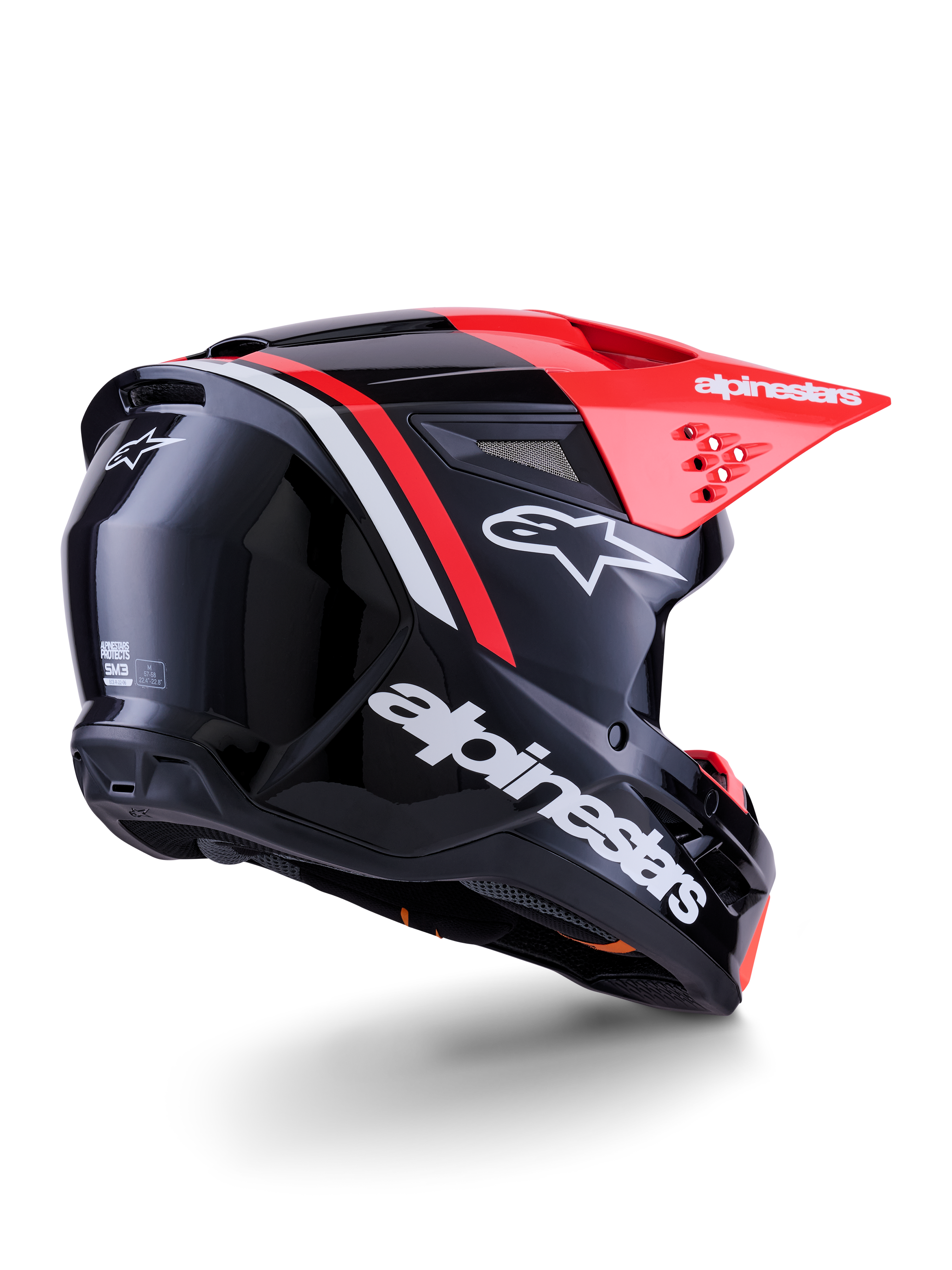Casco Alpinestars S-M3 Radium, casco de motocross, negro, rojo flúor y blanco brillante, vista trasera de tres cuartos que muestra un diseño aerodinámico elegante, logotipos blancos y visera roja brillante, equipo de protección para la cabeza de alto rendimiento para off-road