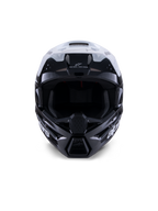 Casco Alpinestars S-M3 Radium, casco de motocross, negro, blanco y gris brillante, vista frontal, con un diseño de carcasa agresivo, visera blanca, mentonera negra y puertos de ventilación con forro de malla.
