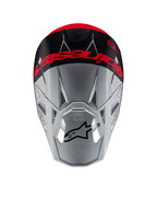 Casco Alpinestars Supertech M10 Flood ECE 22.06, casco de motocross, plateado y negro con naranja fluorescente, vista superior que muestra la marca llamativa en la corona, logotipo Astars negro en la visera, perfil aerodinámico con puertos de ventilación, texturas mate y brillantes.