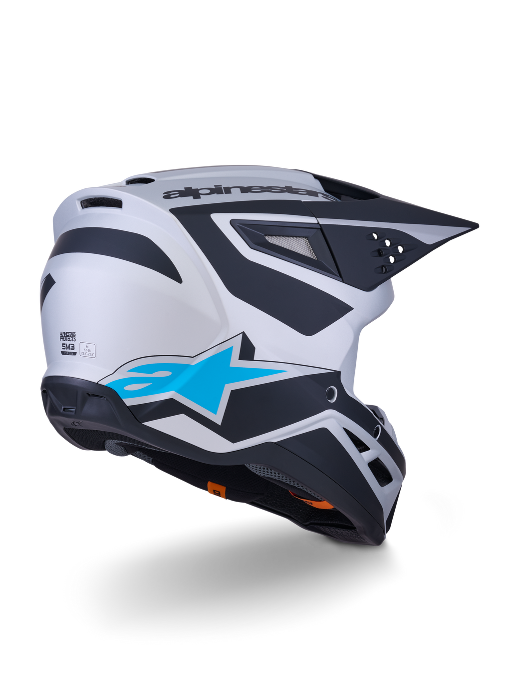 Casco Alpinestars S-M3 Heat ECE 22.06, casco de motocross, plata, azul y negro mate, vista trasera con un gran logotipo de estrella azul y diseños angulares negros, carcasa aerodinámica con puertos de ventilación, protección de alto rendimiento para carreras off-road