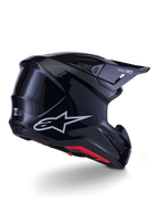 Casco Alpinestars S-M7 Solid, casco de motocross, negro brillante, con una carcasa aerodinámica estilizada, logotipo Astars plateado, forro interior rojo y puertos de ventilación integrados, diseñado para protección en carreras off-road