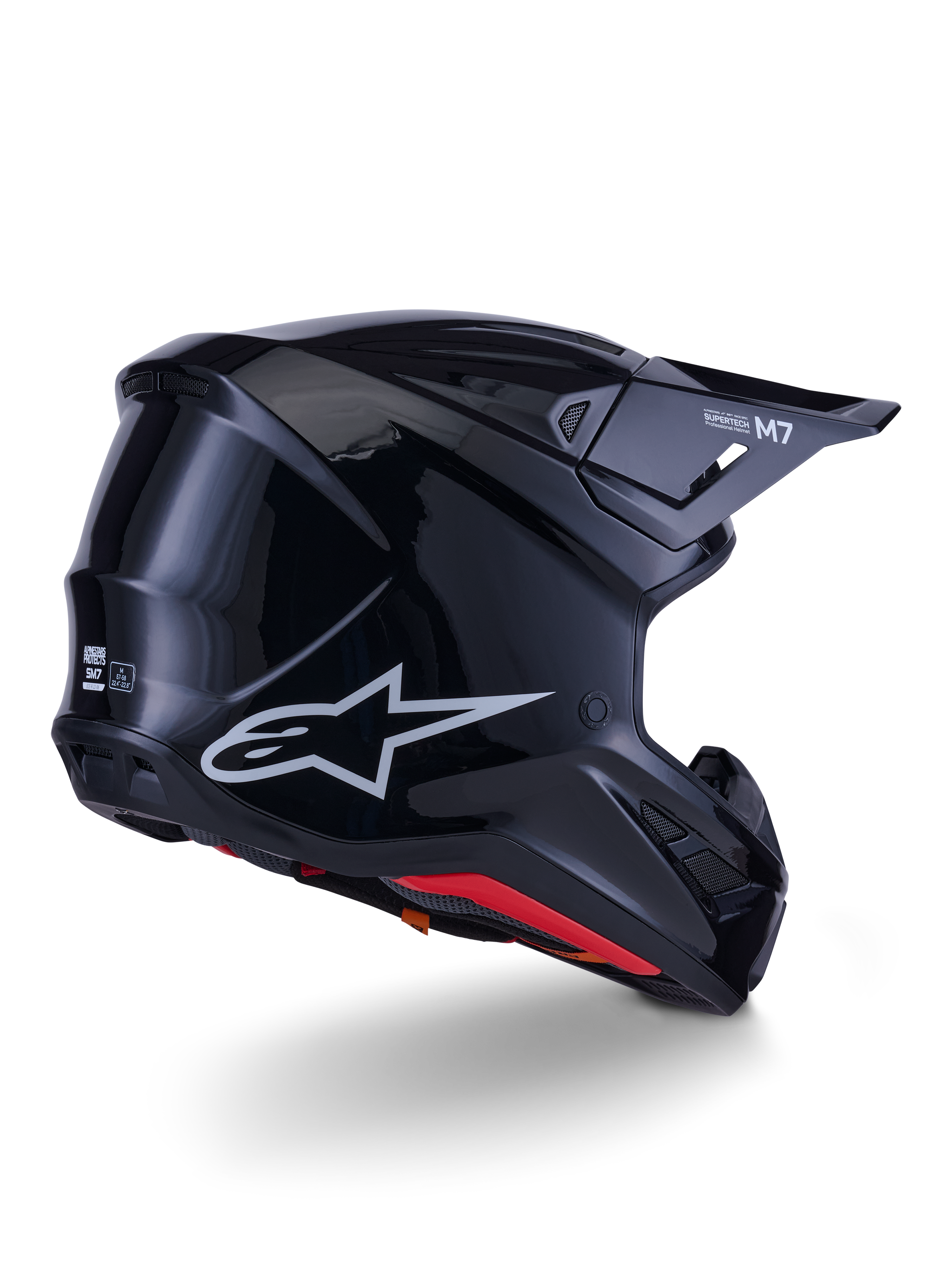 Casco Alpinestars S-M7 Solid, casco de motocross, negro brillante, con una carcasa aerodinámica estilizada, logotipo Astars plateado, forro interior rojo y puertos de ventilación integrados, diseñado para protección en carreras off-road