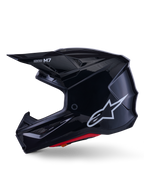 Casco Alpinestars S-M7 Solid, casco de motocross negro brillante, perfil lateral con logotipo blanco de Alpinestars, calota aerodinámica con rejilla de ventilación y acolchado interior rojo, protección avanzada para off-road