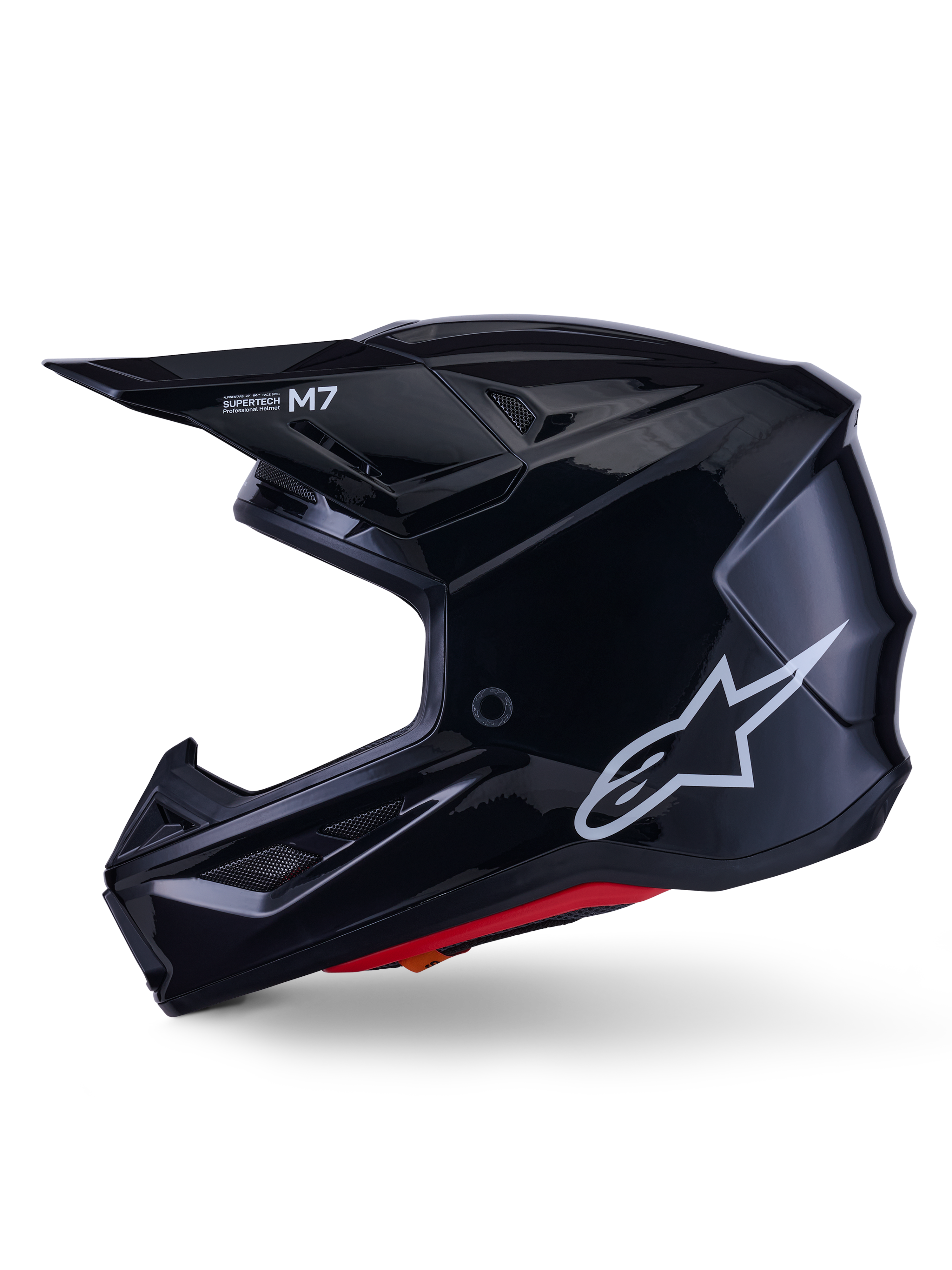 Casco Alpinestars S-M7 Solid, casco de motocross negro brillante, perfil lateral con logotipo blanco de Alpinestars, calota aerodinámica con rejilla de ventilación y acolchado interior rojo, protección avanzada para off-road