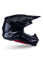 Alpinestars S-M7 Solid Helmet, casco de motocross, negro brillante con logotipo de estrella blanca y acentos rojos, perfil lateral con diseño aerodinámico, rejillas de ventilación angulares y marca Supertech M7 en la visera.