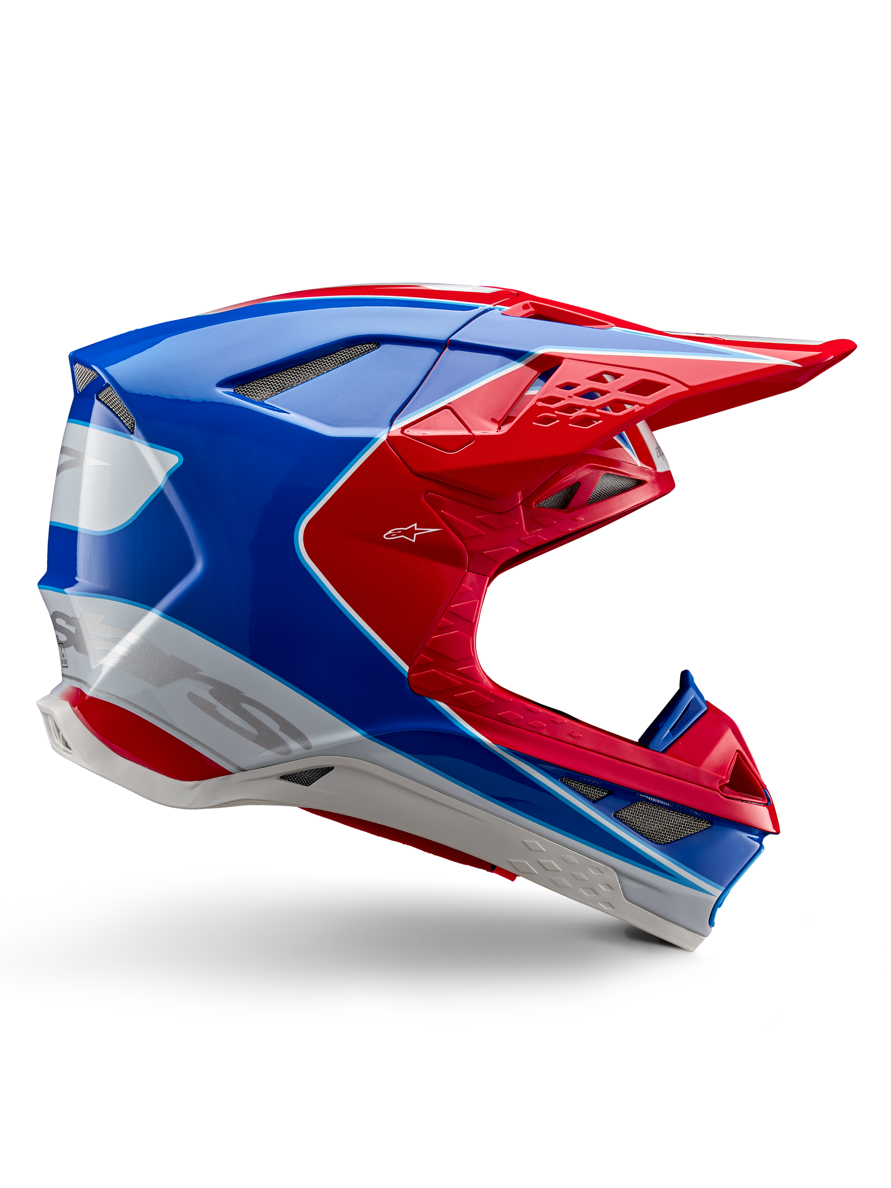 Casco Alpinestars Supertech M10 Aeon, casco de motocross, rojo brillante, azul y blanco, acabado brillante, perfil lateral aerodinámico con múltiples rejillas de ventilación cubiertas de malla, contornos angulares y visera