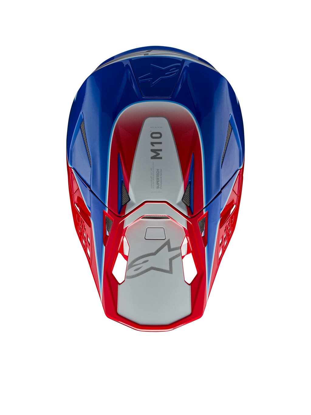 Casco Alpinestars Supertech M10 Aeon, casco de motocross, rojo y azul brillante, vista superior que muestra el panel central plateado con la marca M10, calota aerodinámica con detalles en rojo y azul, puertos de ventilación de malla, protección para la cabeza de motocross de alto rendimiento