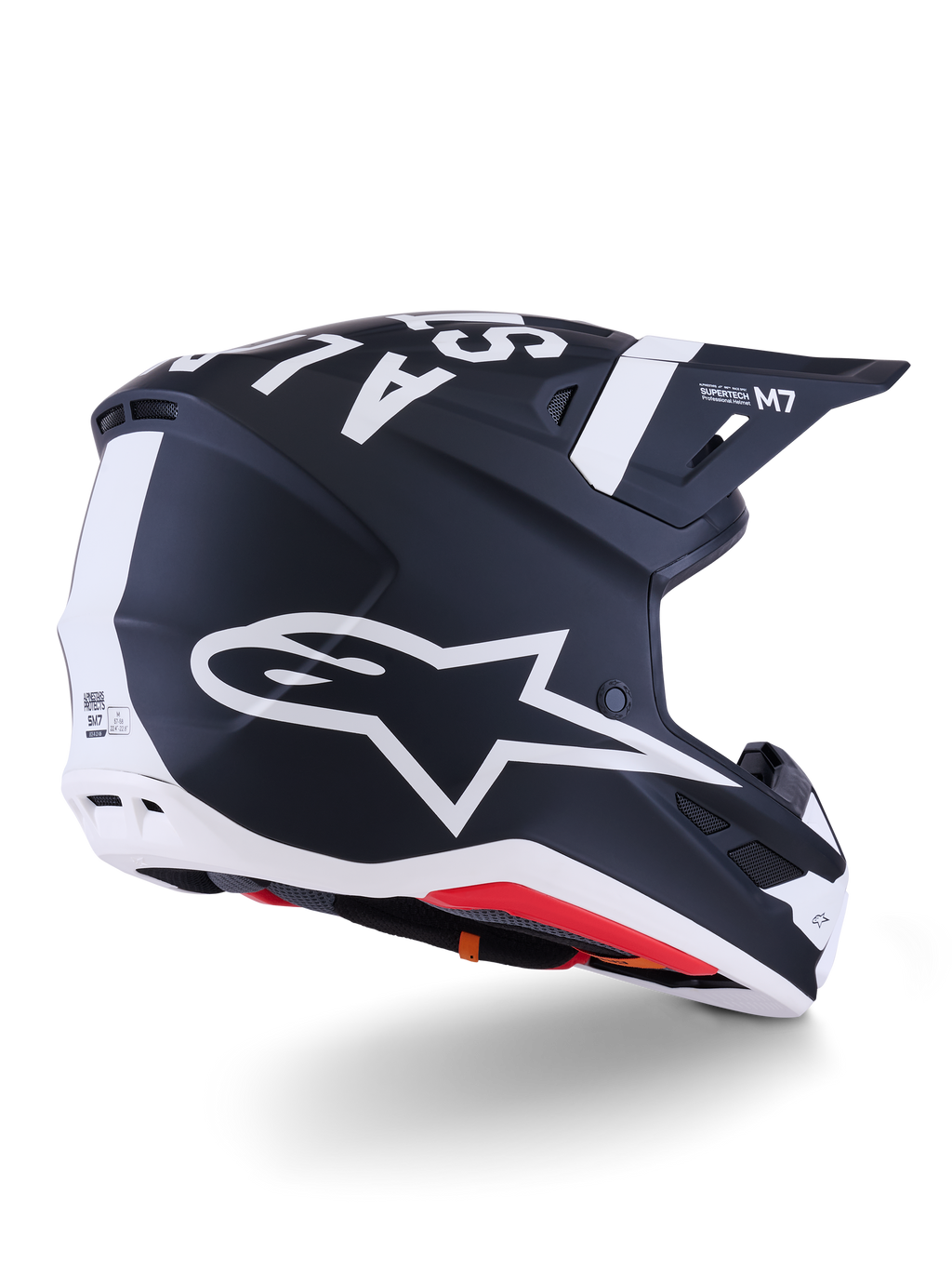 Casco Alpinestars S-M7 Dasher, casco de motocross, negro mate y blanco, vista trasera de tres cuartos con un gran logotipo A-star blanco en el lateral, marca blanca destacada en la parte superior, diseño de calota aerodinámica con puertos de ventilación visibles y acolchado rojo.