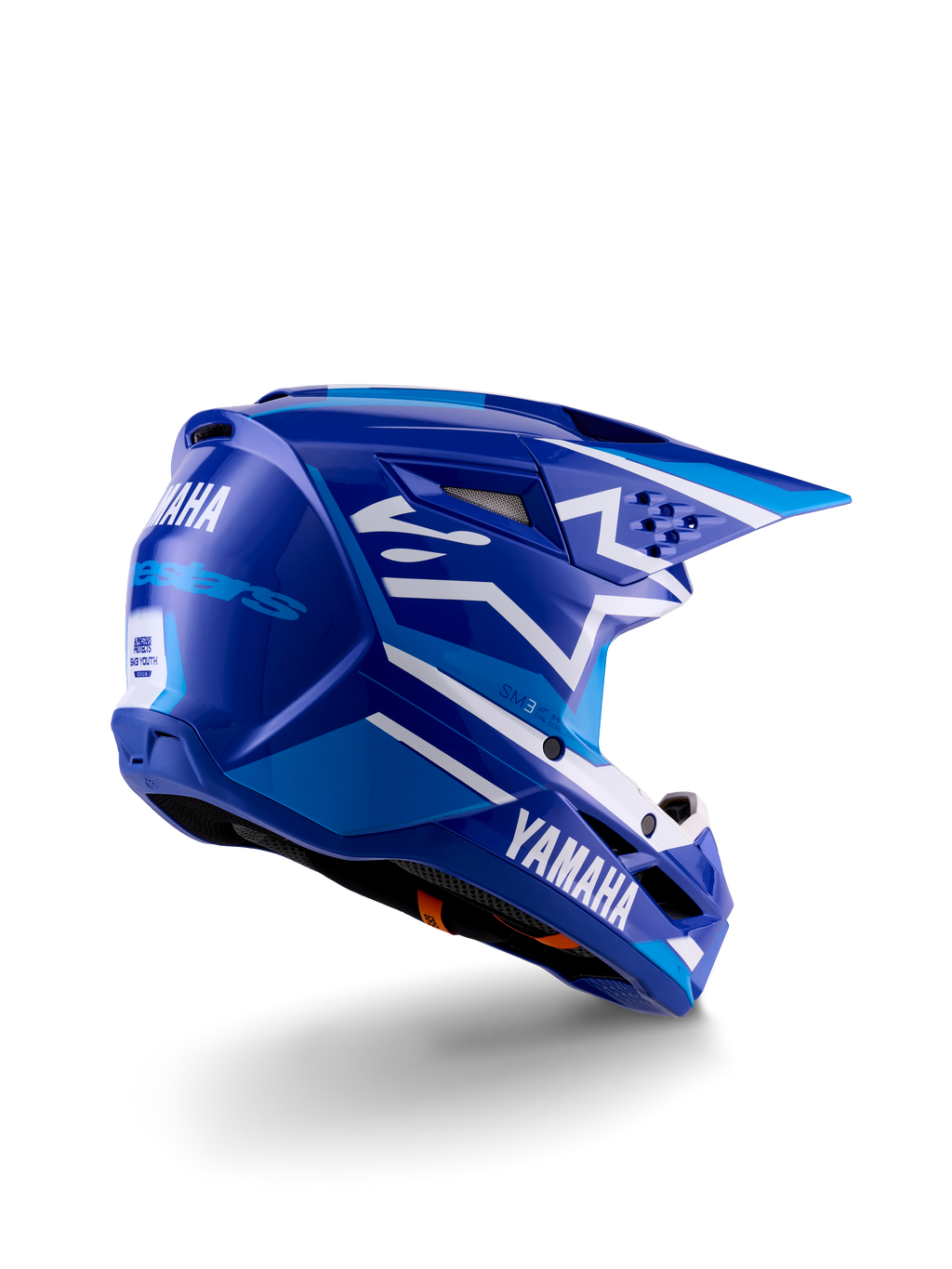 Casco de motocross Alpinestars Yamaha S-M3 Juvenil, azul y blanco brillante, con logotipos de Yamaha destacados en el lateral y la parte trasera, diseño de calota aerodinámica con ventilación trasera, protección para la cabeza específica para jóvenes en vista de tres cuartos trasera.