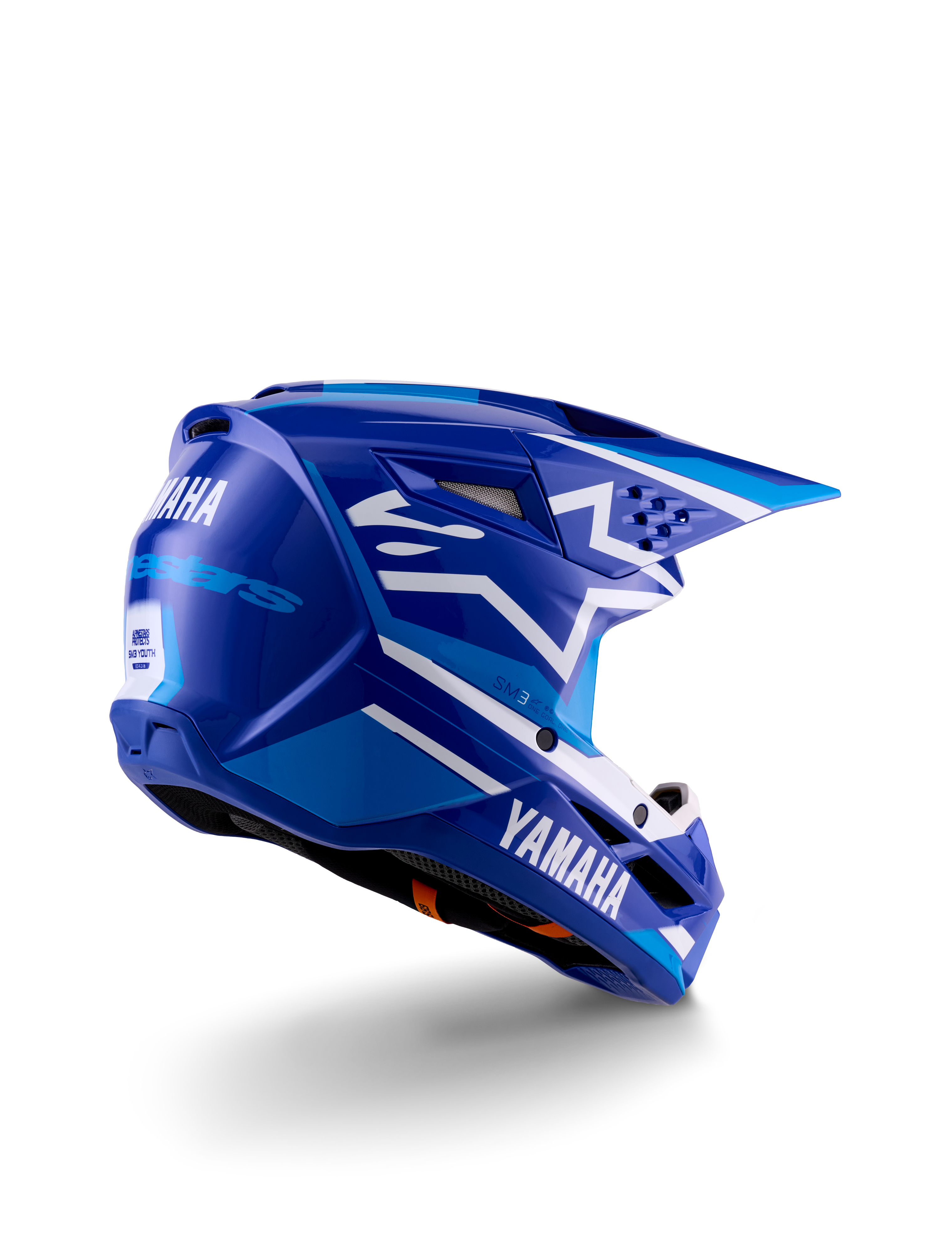 Casco de motocross Alpinestars Yamaha S-M3 Juvenil, azul y blanco brillante, con logotipos de Yamaha destacados en el lateral y la parte trasera, diseño de calota aerodinámica con ventilación trasera, protección para la cabeza específica para jóvenes en vista de tres cuartos trasera.