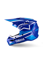 Casco de Motocross Yamaha S-M3 Juvenil, azul y blanco brillante, vista de perfil lateral, con marca Yamaha destacada en la mentonera y logo de la estrella de Alpinestars, calota aerodinámica con múltiples puertos de ventilación y visera integrada.