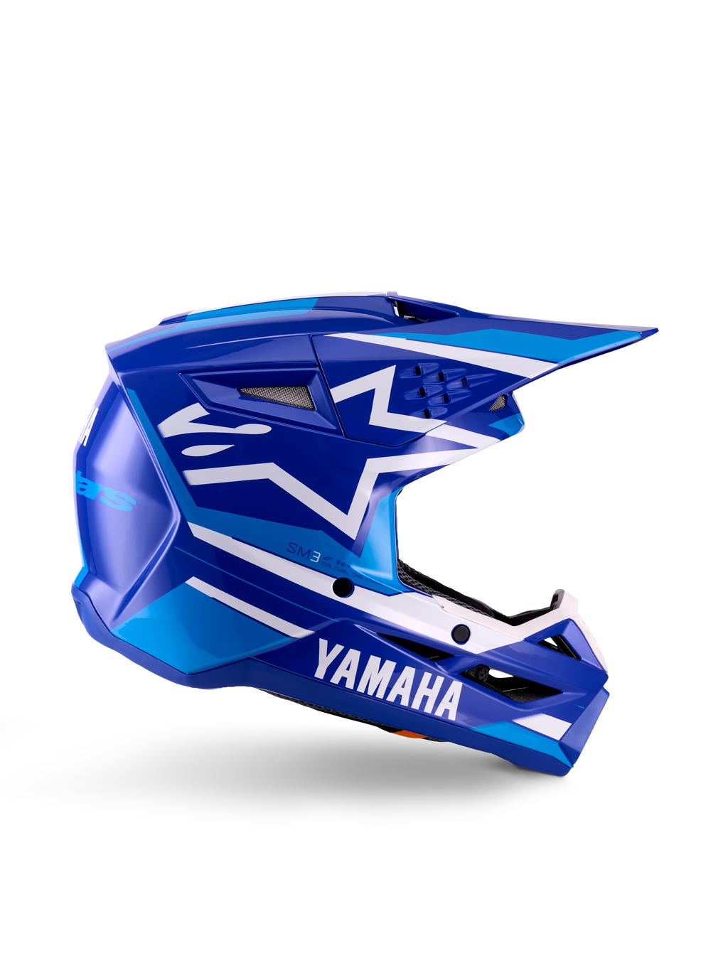 Casco de motocross juvenil Yamaha S-M3, azul y blanco brillante, vista de perfil lateral con marca Yamaha destacada y logo de estrella de Alpinestars, diseño geométrico con detalles en azul claro, calota ventilada con visera larga, protección para la cabeza off-road certificada ECE 22.06