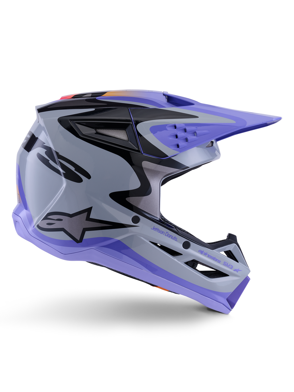 Casco juvenil Alpinestars S-M3 Jettson, casco de motocross, gris, morado y negro brillante, perfil lateral con gráficos angulares definidos y marca 'Jettson Donuts', diseño de calota aerodinámica con puertos de ventilación y logotipo de Alpinestars, equipo de protección off-road juvenil de alto rendimiento