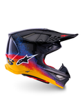 Alpinestars Supertech M10 Black Hole Edición Limitada, casco de motocross, calota negra con diseño de salpicaduras en degradado rojo, azul y amarillo, logotipo de estrella blanco en el lateral, perfil aerodinámico con puertos de ventilación cubiertos de malla, acolchado interior rojo y visera negra larga.