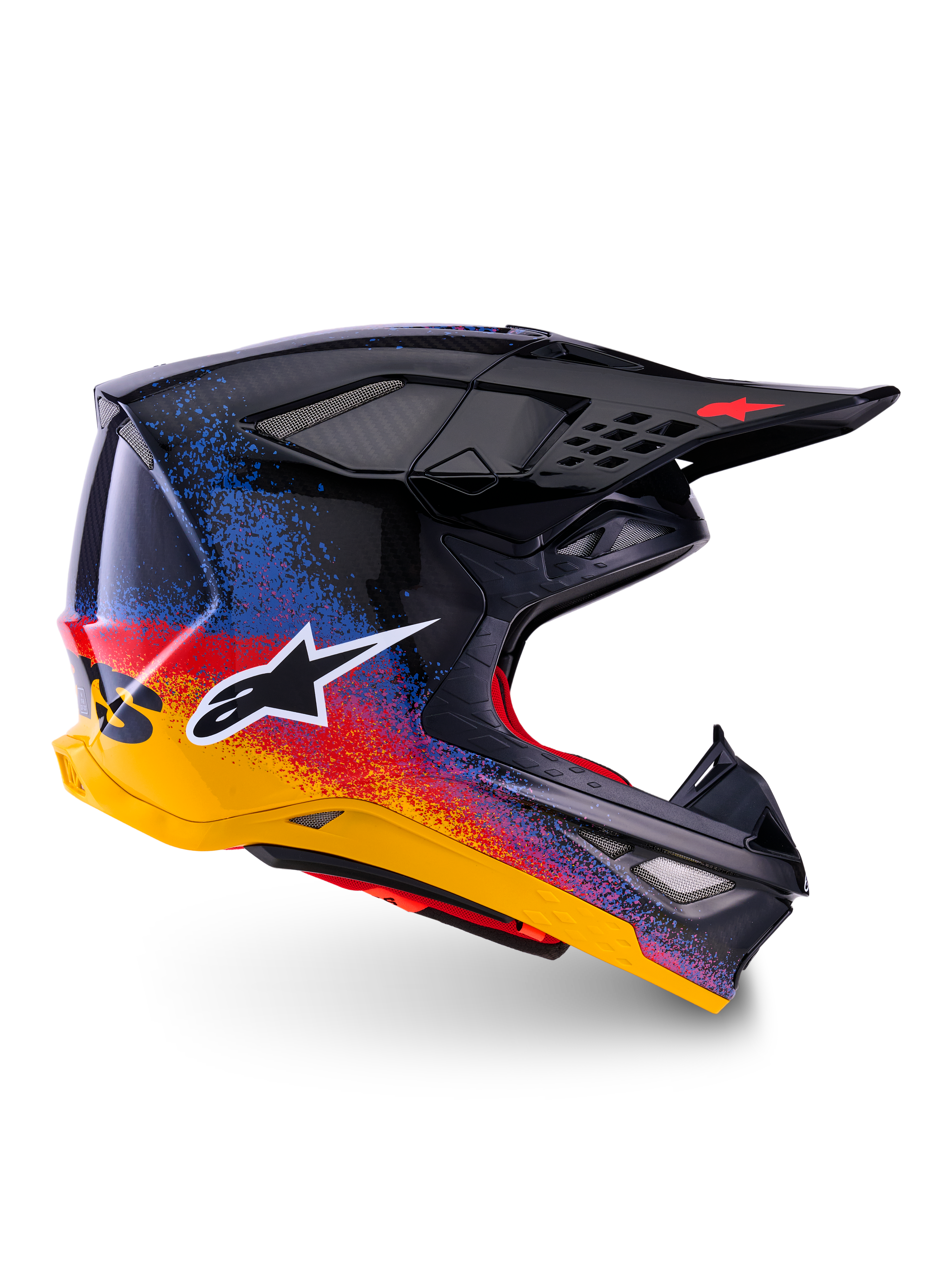 Alpinestars Supertech M10 Black Hole Edición Limitada, casco de motocross, calota negra con diseño de salpicaduras en degradado rojo, azul y amarillo, logotipo de estrella blanco en el lateral, perfil aerodinámico con puertos de ventilación cubiertos de malla, acolchado interior rojo y visera negra larga.