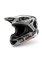 Casco Alpinestars Edición Limitada S-M7 Wolf Dust, casco de motocross, Dune Black Glossy, calota gris claro con letras 'ASTARS' de estilo gótico y logotipo de estrella en negro, detalle rojo en el borde inferior, con visera de alto rendimiento y múltiples entradas de aire, vista frontal de tres cuartos