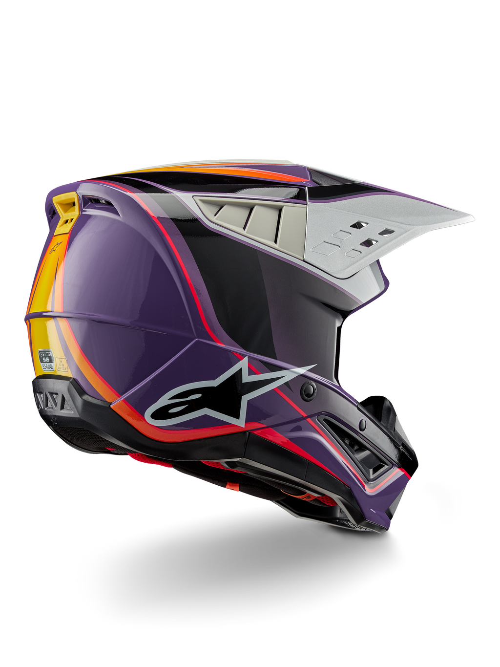Alpinestars S-M5 Sail Helmet ECE, casco de motocross, violeta, negro y plata brillante, con detalles de rayas naranjas y amarillas, logotipo de estrella negra grande, perfil aerodinámico con puertos de ventilación traseros, acabado brillante para carreras todoterreno
