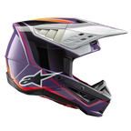 Alpinestars S-M5 Sail Helmet ECE, casco de motocross, violeta, negro y plateado brillante, con llamativos gráficos en naranja y rojo, visera plateada ventilada, calota aerodinámica con logo de estrella blanca y protección profesional para competiciones off-road