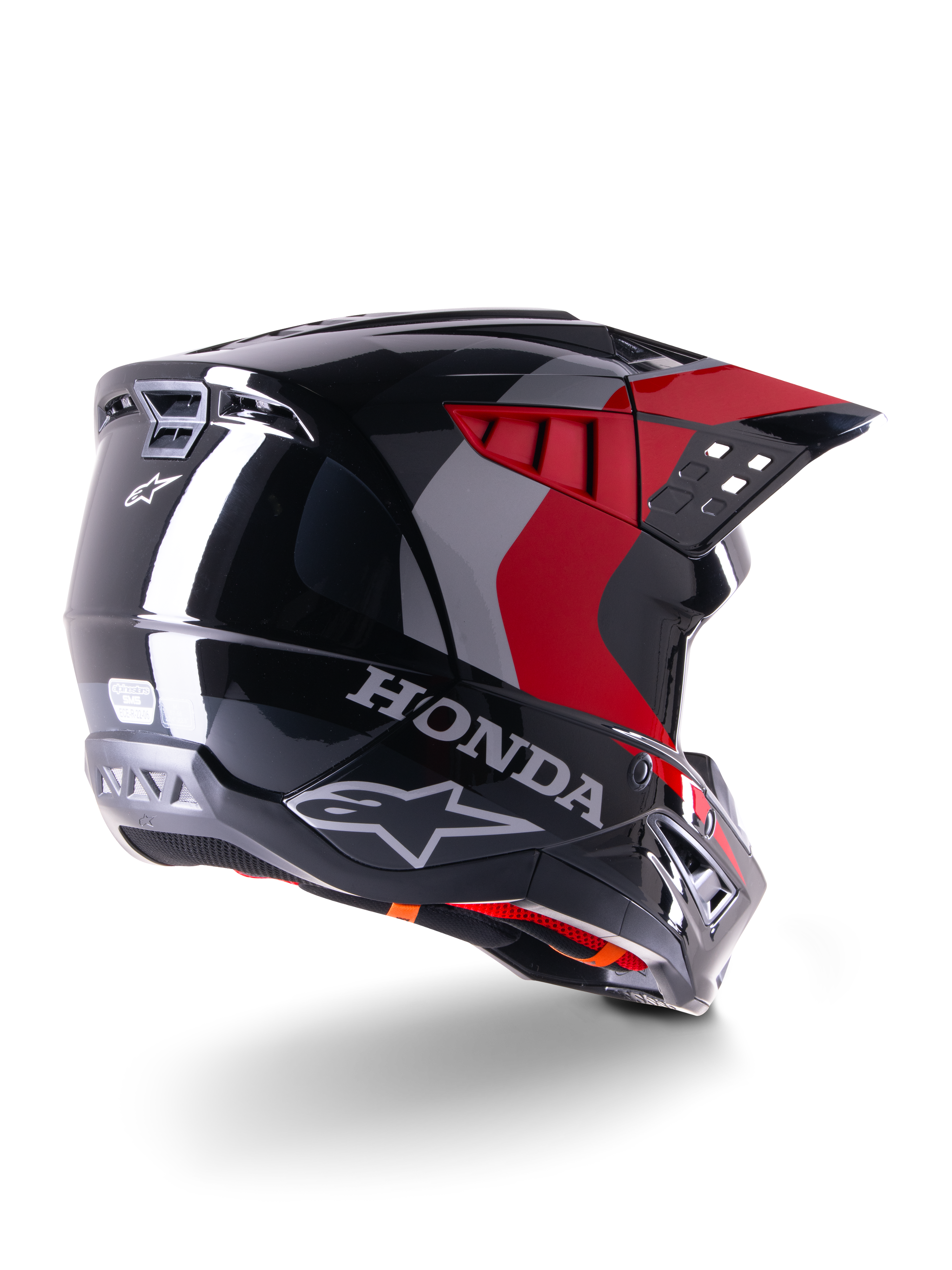Alpinestars Honda S-M5 Helmet ECE, casco de motocross, negro y rojo brillante, vista trasera en tres cuartos con la marca Honda y logotipos de Alpinestars, acabado brillante con acentos gráficos en rojo y gris, diseñado para protección todoterreno