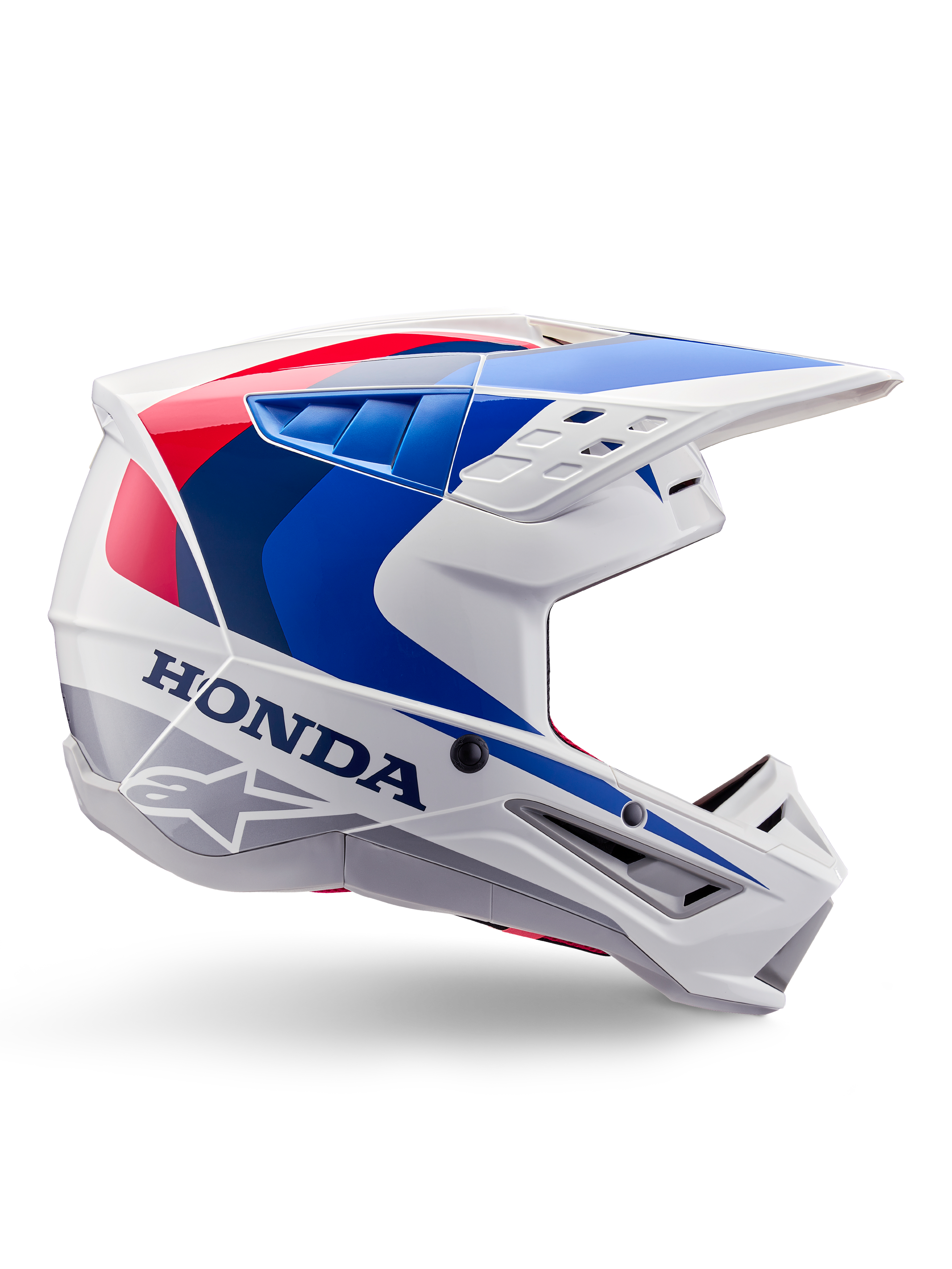 Alpinestars Honda S-M5 Helmet ECE, casco de motocross, blanco, azul y rojo, vista de perfil lateral, diseño aerodinámico con visera integrada, múltiples aperturas de ventilación, acabado brillante, marca Honda y logotipo de Alpinestars