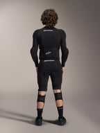 Chaqueta de protección Alpinestars A-Impact Plasma - Manga larga, vista posterior, negra con logotipos blancos de Alpinestars, usada con pantalones cortos de protección y rodilleras para una protección corporal completa de mountain bike