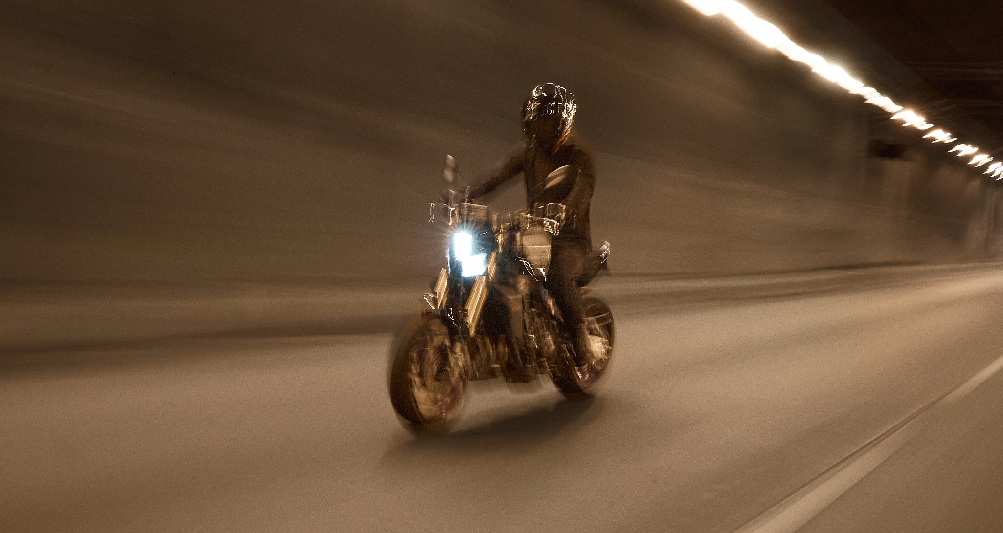 Alpinestars Aeroshell Airflow Jacket, black lightweight textile road jacket, shown on a rider in motion through a tunnel.