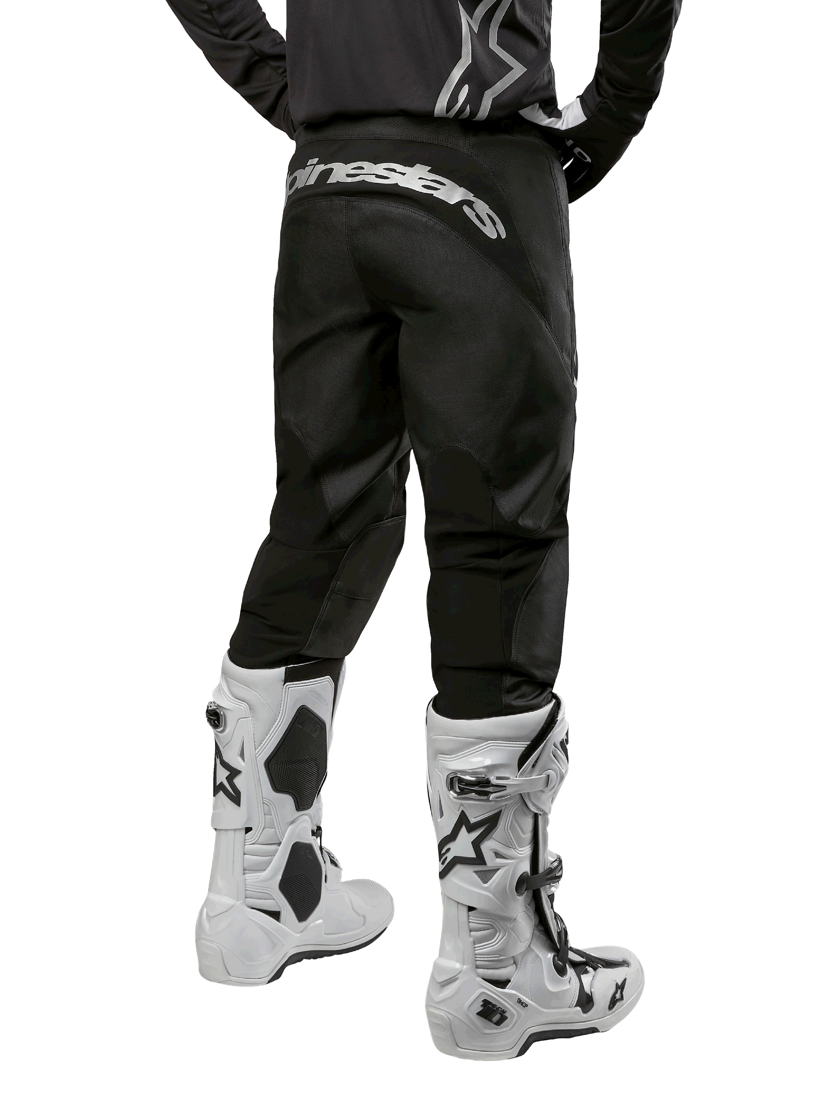 Alpinestars 2024 Fluid Graphite Gear Set, vista posterior de pantalones de motocross negros y grises con el logotipo de Alpinestars en blanco en la zona del asiento, combinados con botas de motocross blancas y negras, equipo especializado para carreras todoterreno