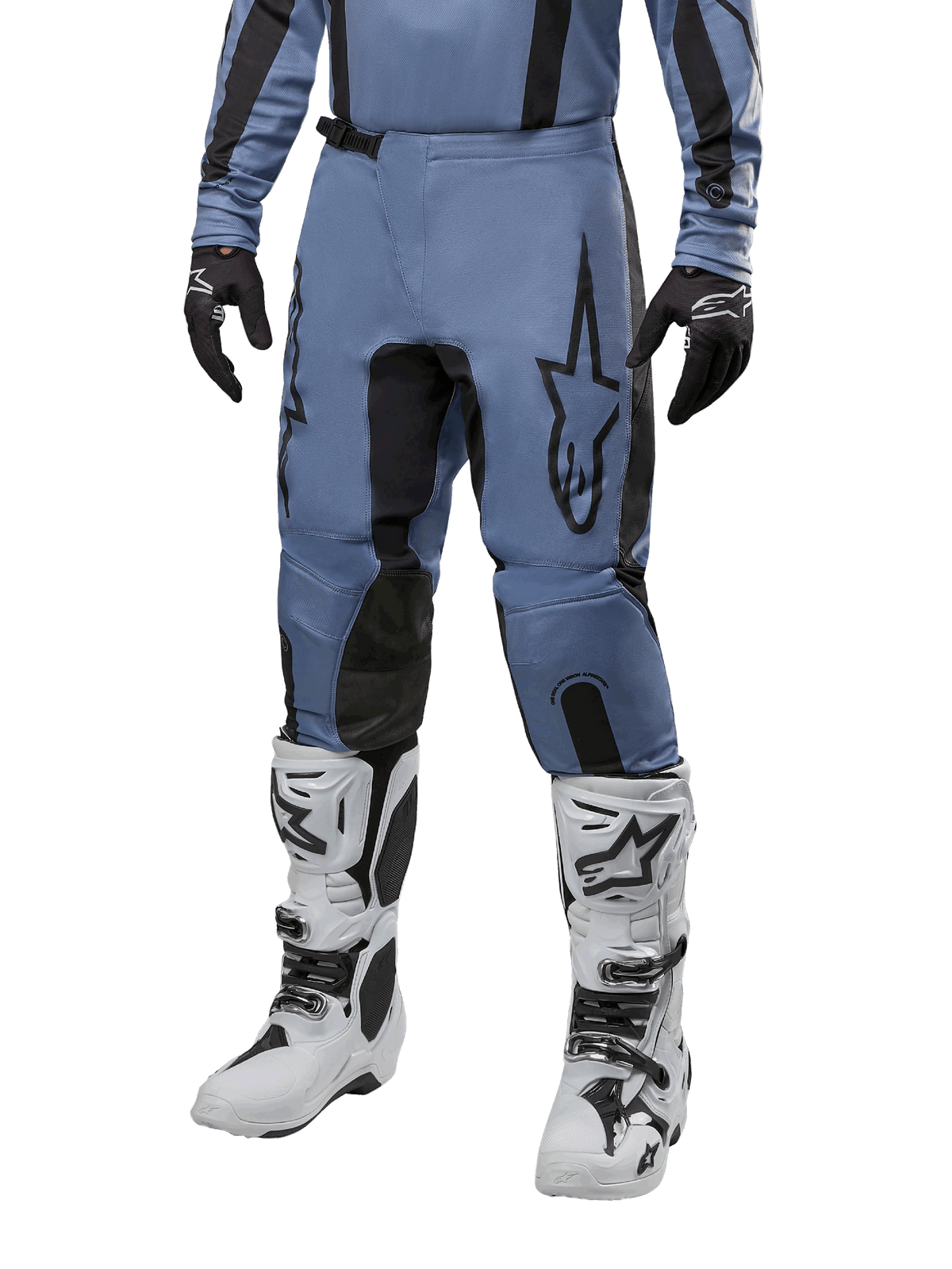 Alpinestars 2024 Fluid Lurv Pants, pantalones de motocross, azul claro y negro, usados con jersey de manga larga a juego y botas de motocross blancas, con un prominente logotipo de estrella negra en el muslo y paneles internos de la rodilla reforzados, vista frontal sobre fondo blanco