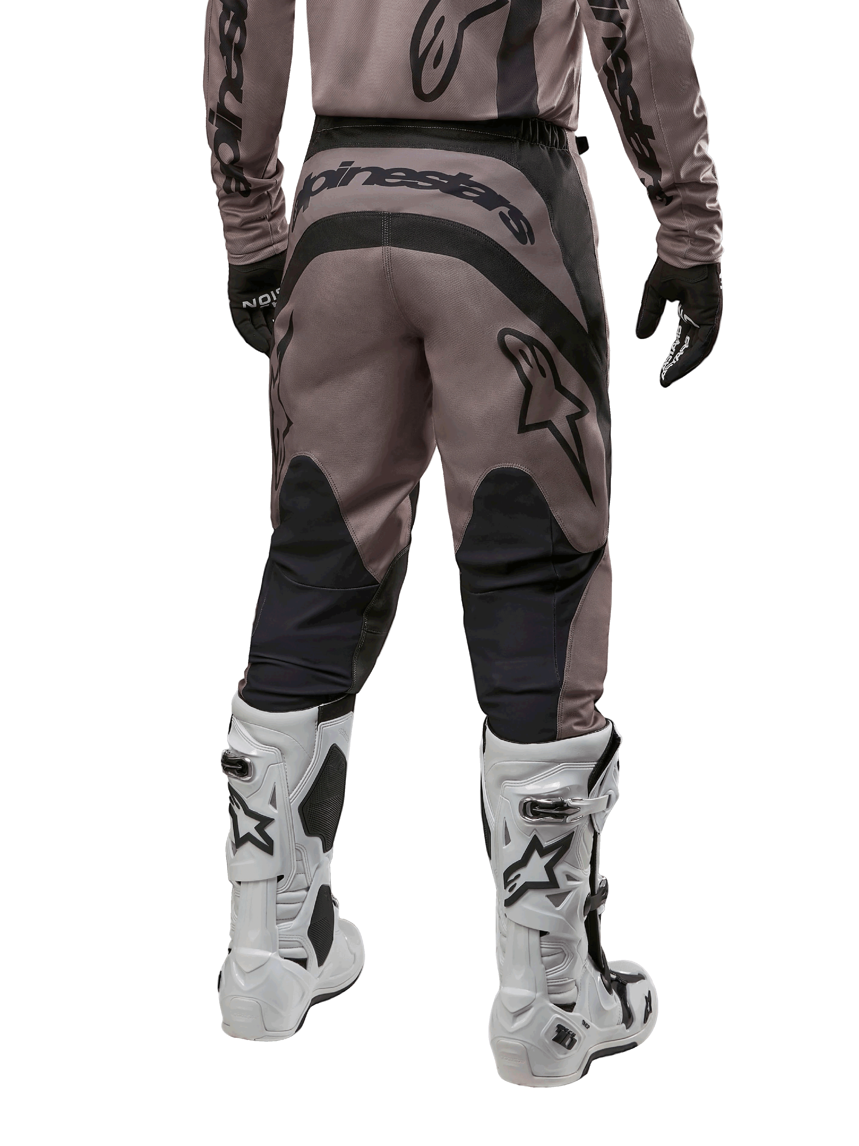 Pantalones Alpinestars Fluid Lurv 2024, pantalones de motocross, Mud Black, vista trasera con gran logotipo negro de Alpinestars en el asiento y paneles negros en las pantorrillas, combinados con botas de motocross blancas y negras y jersey a juego