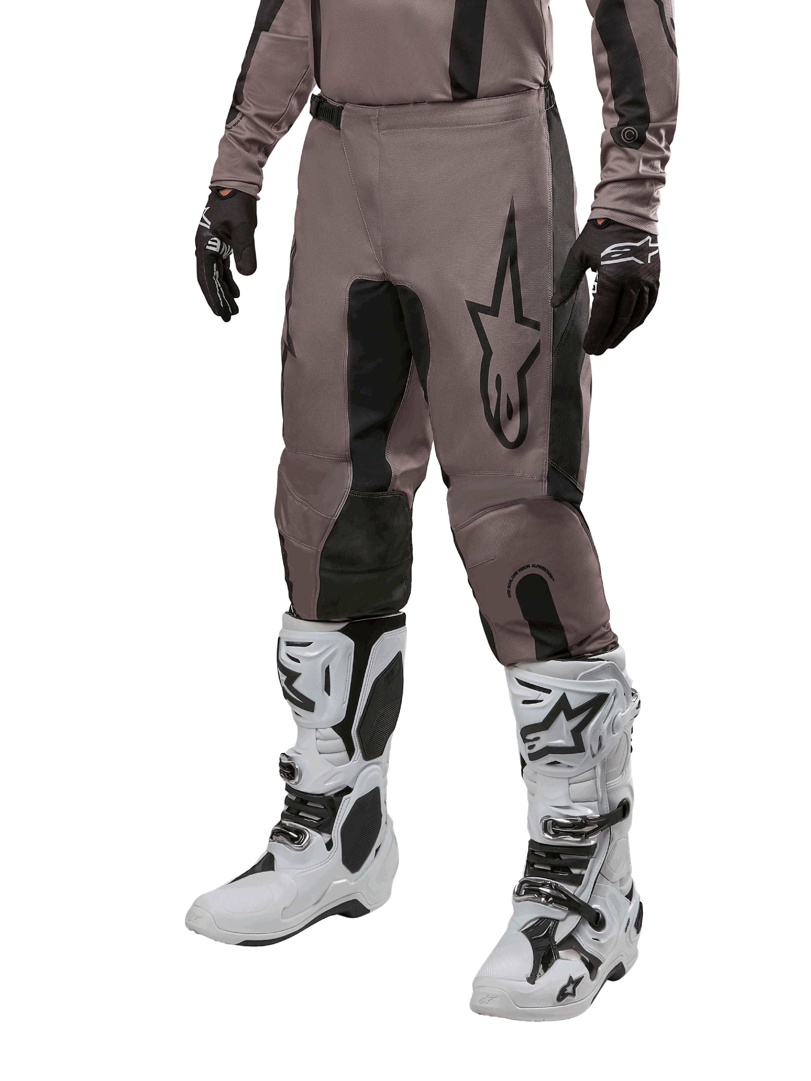 Alpinestars 2024 Fluid Lurv Pants, pantalones de motocross, negro barro y negro, con el logo de Alpinestars, usados con guantes negros y botas de motocross blancas, diseño deportivo para carreras todoterreno