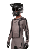 Alpinestars 2024 Fluid Lurv Jersey, jersey de motocross, negro y gris, diseño de manga larga con rayas negras curvas y logotipos, usado con pantalones a juego y un casco de motocross negro, conjunto coordinado para carreras off-road
