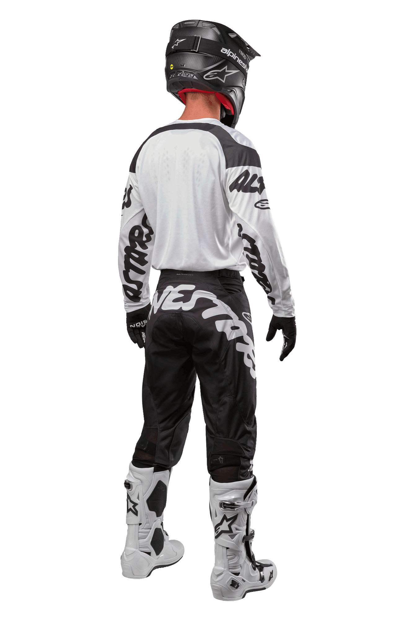 Alpinestars 2024 Racer Hana Pants, pantalones de motocross negros y blancos, vista trasera mostrando el diseño con logo Alpinestars, equipamiento completo con jersey blanco, casco negro y botas blancas protectoras