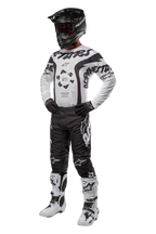 Alpinestars 2024 Racer Hana Pants, pantalones de motocross negros con logos blancos, equipo completo de motocross con jersey blanco y negro, casco negro, guantes oscuros y botas blancas con detalles negros