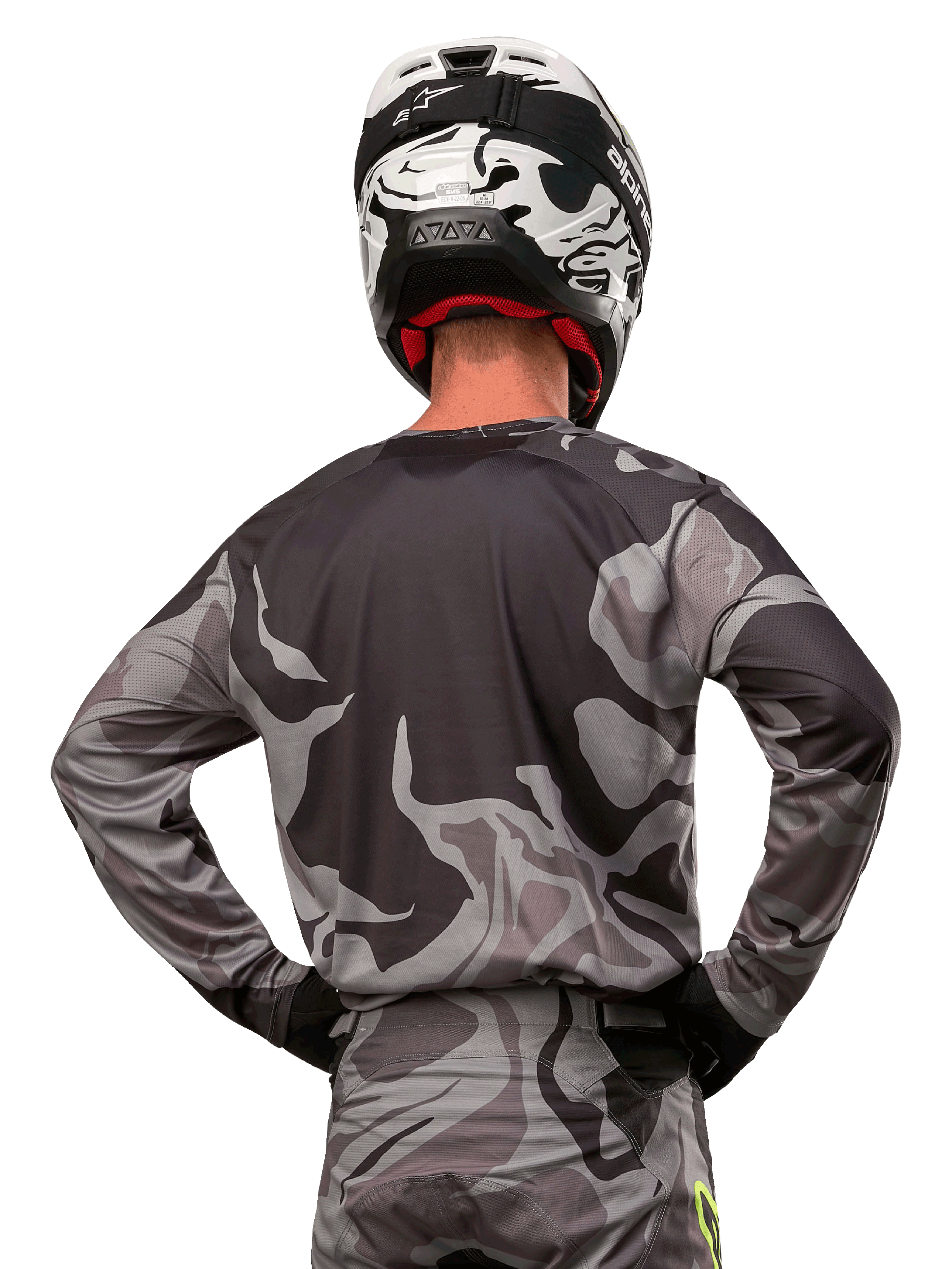 Alpinestars 2024 Racer Tactical Jersey, jersey de motocross, Cast Gray Camo Magnet, vista posterior que muestra el patrón de camuflaje gris y negro, usado con pantalones a juego y un casco blanco y negro, equipamiento profesional de carreras todoterreno